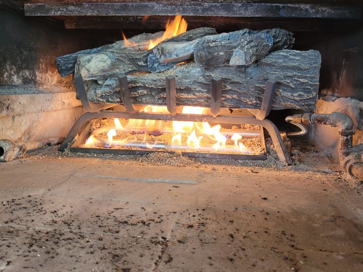 Gas log set burning with a clean steady flame across the burner after annual service